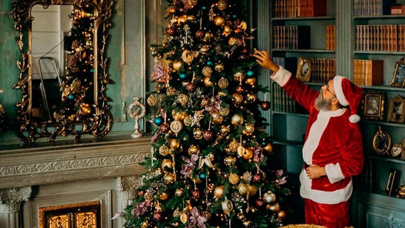 Santa Claus face à un arbre de Noel.